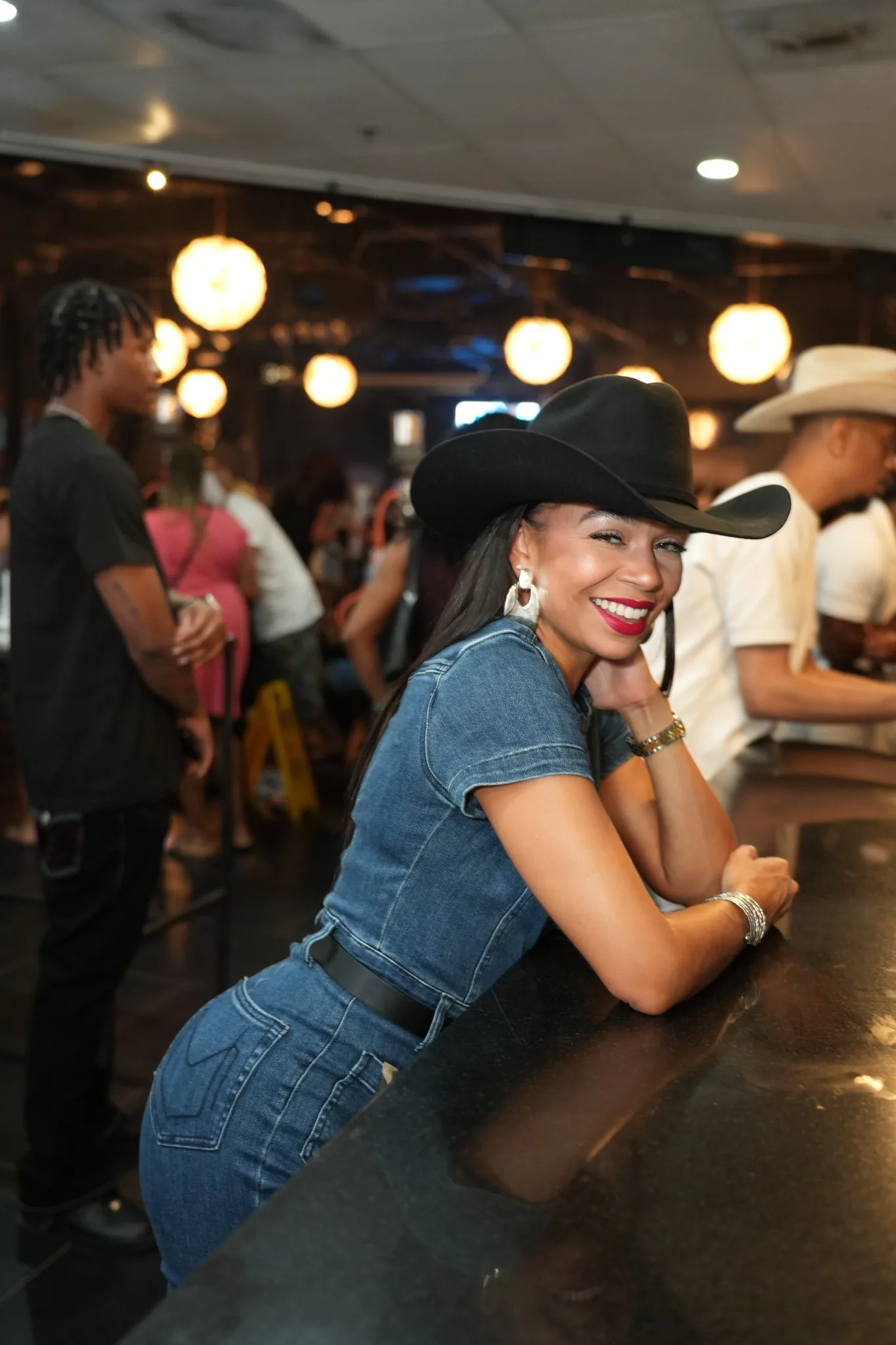 Courtney smiling in a black cowboy hat